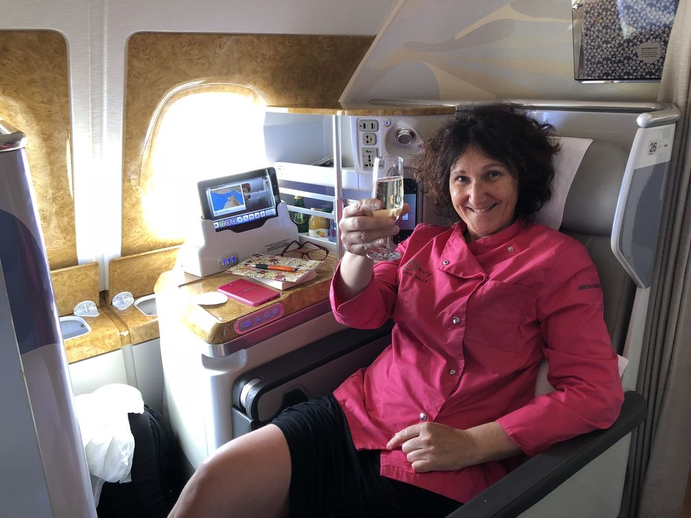 Mikuy dans l'avion avec une coupe de champagne